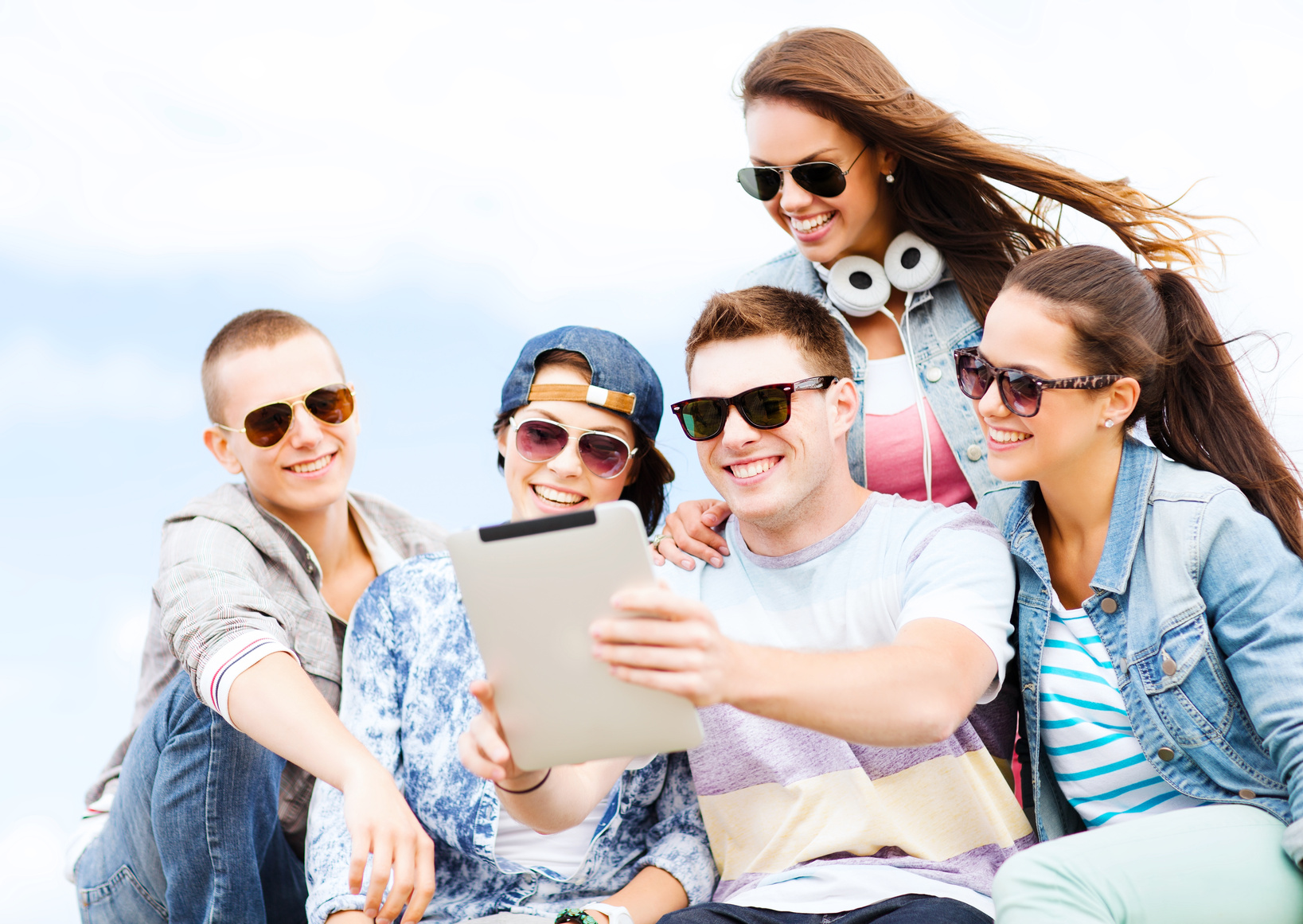 group of teenagers looking at tablet pc